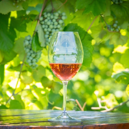 wine glass with grapes in background